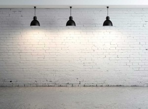 Pared de interior de ladrillo visto blanco con tres lamparas industriales de techo