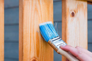 Mano con pincel aplicando Pintura en madera