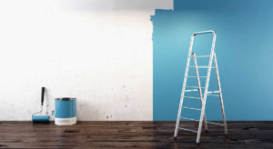 Escalera y bote de pintura media pared pintada de azul
