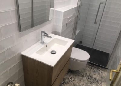 Baño reformado mueble de baño con lavabo grifos y suelo rústico