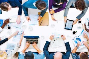 Vista superior de ejecutivos trabajando en mesa con ordenadores de empresa de reformas