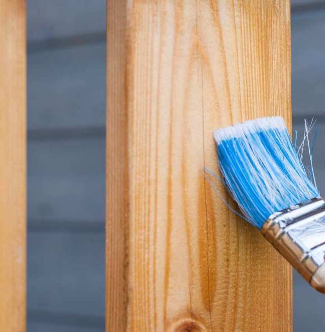 Trabajos de pintura con pincel azul sobre madera marrón claro