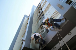 Operarios en altura trabajando en rehabilitación de fachadas de edificio