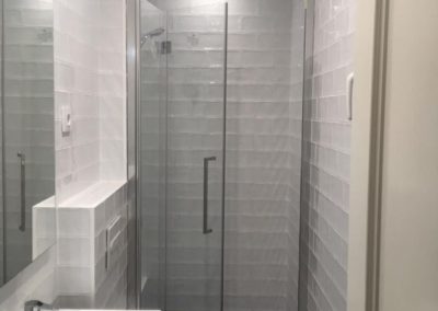 Baño reformado mueble de baño con lavabo grifos suelo rústico ducha y puerta de entrada